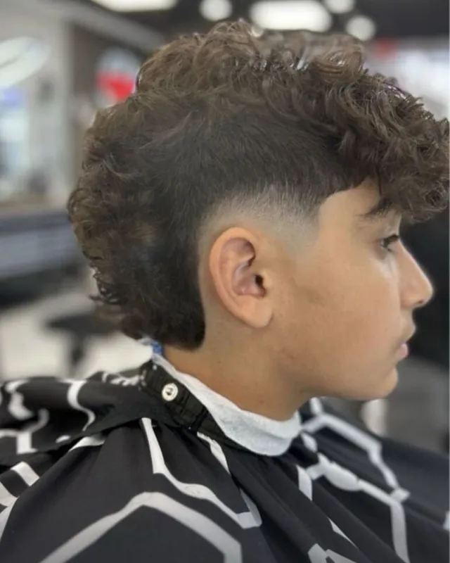 Burst fade with curly length at the back, cut at Top Style