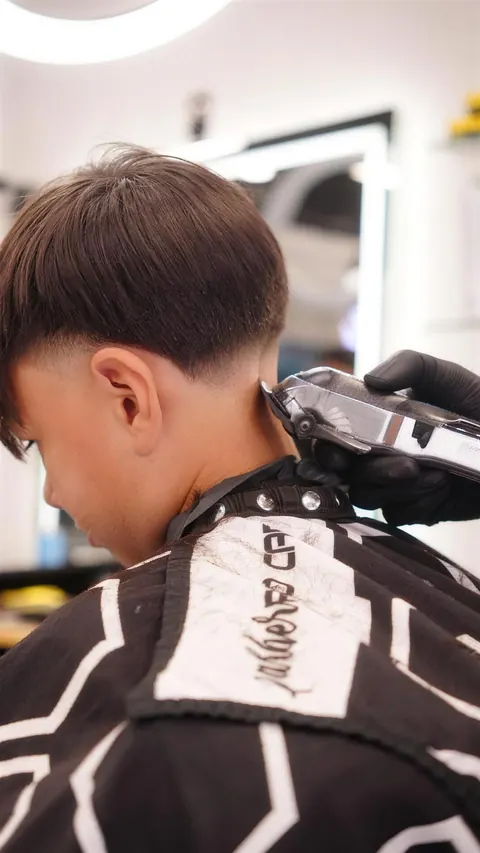 Back view of a boy’s textured crop and low taper during the cut