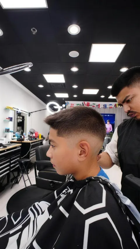 Boy in the chair with a fresh mid fade, side view
