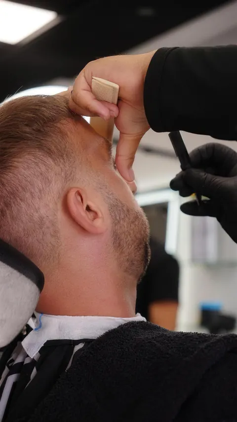 Close-up of a straight razor cleaning up the neckline